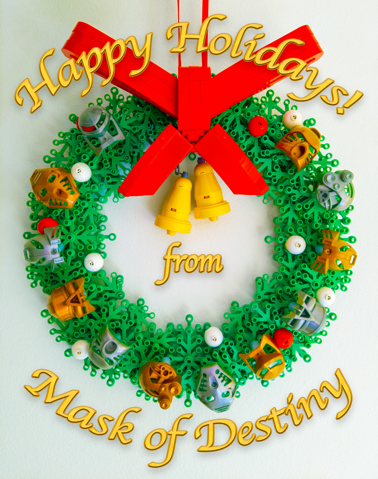 "Happy Holidays! from Mask of Destiny" over a LEGO wreath creation featuring a large red bow, 2 bells, and 6 gold and 6 silver Toa Mata masks.